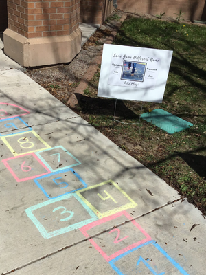 colorful hopscotch is drawn in front of the library.
